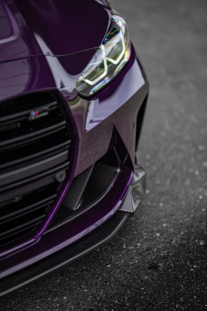 Close-up of the carbon OEM++ SPL1 front lip on a purple BMW G80 M3