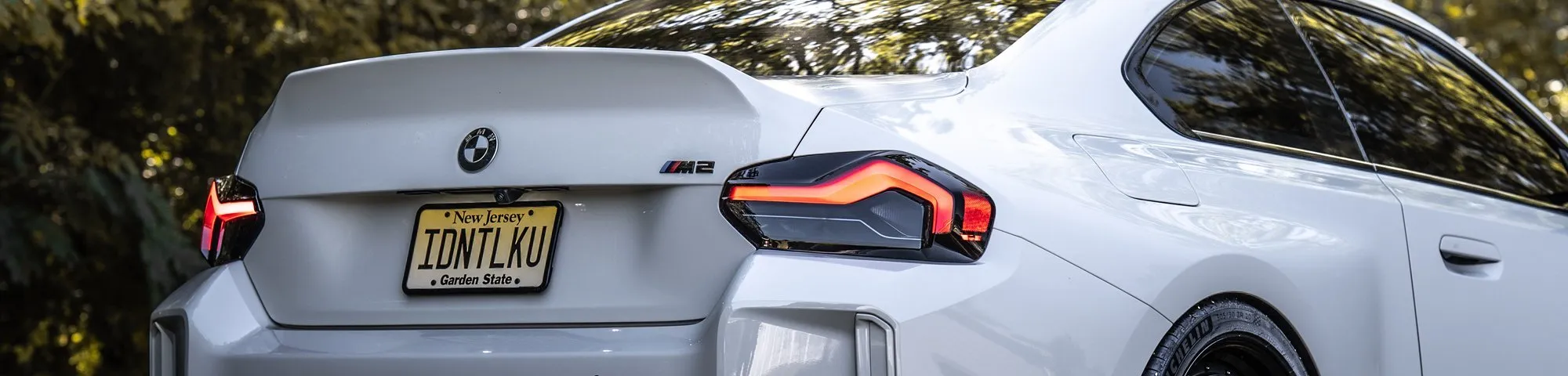 Rear of a white BMW M2 with New Jersey plates
