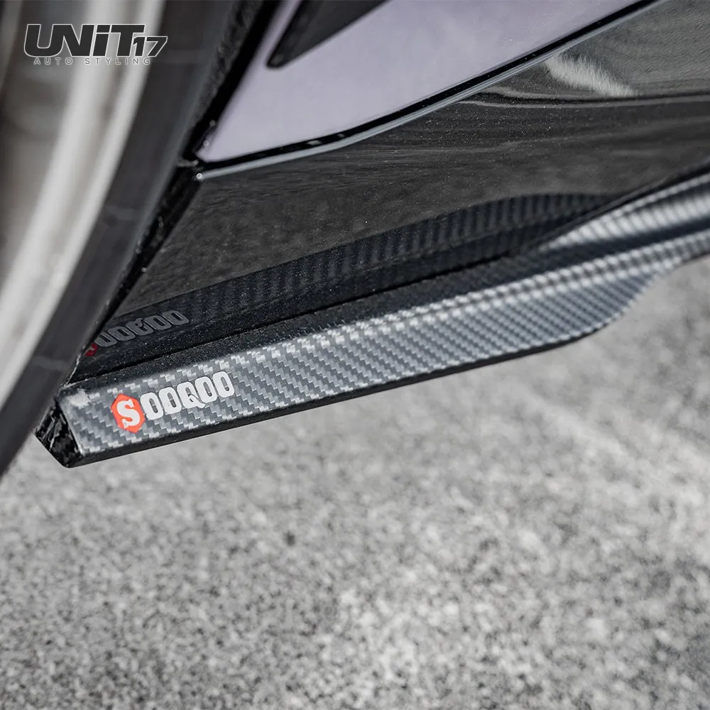 Branded end of the installed carbon side skirt beside the wheel