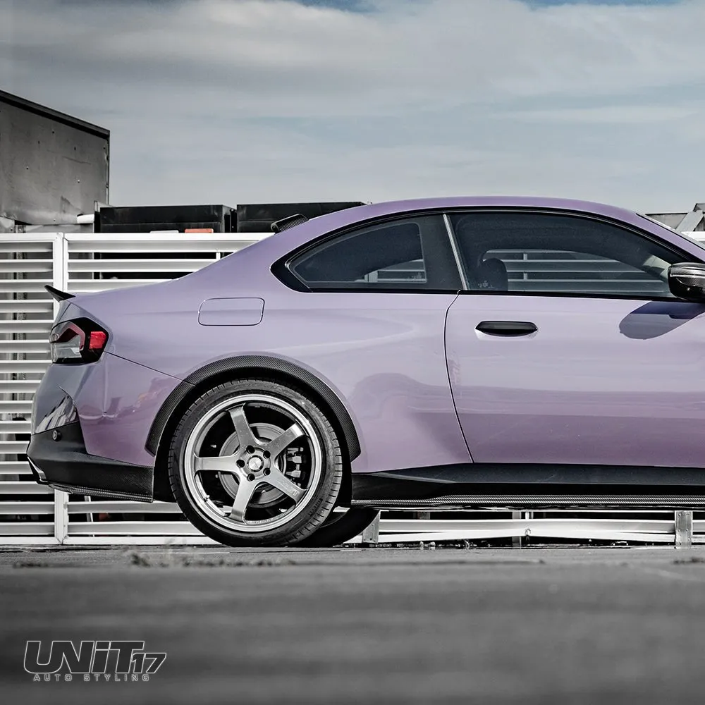 Rear side view of a purple BMW G42 showing the carbon side skirt